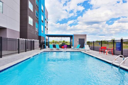a swimming pool with chairs and a building at Tru by Hilton Auburn in Auburn