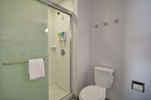 a bathroom with a toilet and a glass shower at Home2 Suites By Hilton Blue Ash Cincinnati in Blue Ash