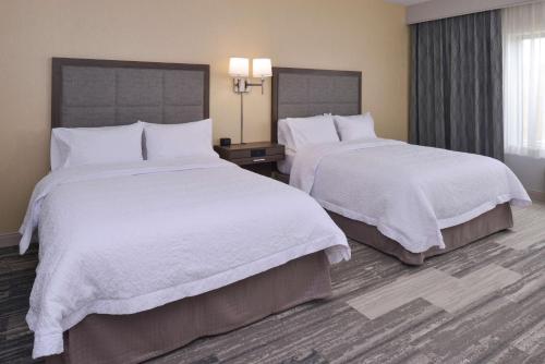 a hotel room with two beds with white sheets at Hampton Inn & Suites Cincinnati-Mason, Ohio in Mason