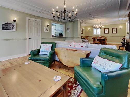 sala de estar con sillas verdes y mesa en The 1827 House, en West Dover