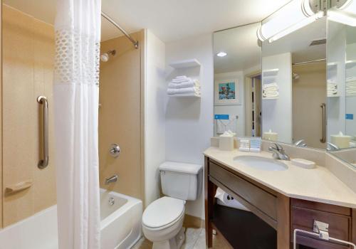 a bathroom with a toilet and a sink and a bath tub at Hampton Inn Los Angeles/Carson in Carson