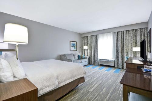 Habitación de hotel con cama y TV en Hampton Inn Blue Ash/Cincinnati, OH, en Blue Ash