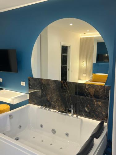 uma casa de banho com banheira e espelho grande em La Lepre Artemide em Nápoles