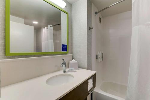 La salle de bains est pourvue d'un lavabo, d'un miroir et d'une baignoire. dans l'établissement Hampton Inn Cumming, à Cumming