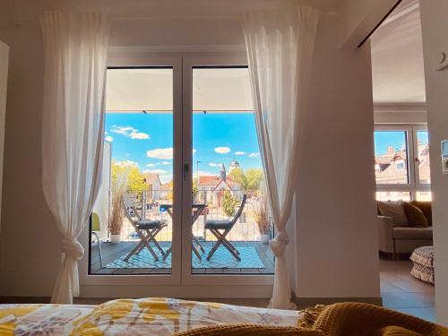 a bedroom with a sliding glass door with a view of a patio at Kapellenblick Seligenstadt in Seligenstadt