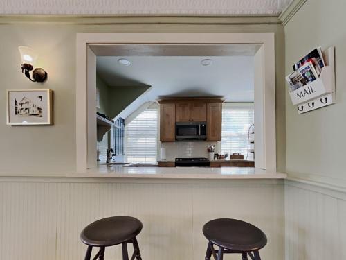 a kitchen with two stools in front of a mirror at The 1827 House in West Dover