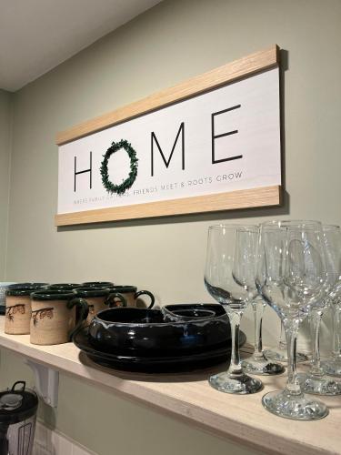a shelf with wine glasses and a sign on it at The 1827 House in West Dover