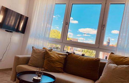 a living room with a couch and large windows at Kapellenblick Seligenstadt in Seligenstadt