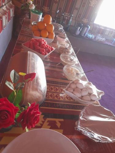 a long table with eggs and oranges on it at Wadi Rum Nature Stars Camp in Wadi Rum