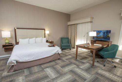 a hotel room with a bed and a desk and a television at Hampton Inn & Suites Cincinnati-Union Centre in West Chester