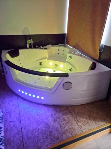 a white bath tub with lights in a bathroom at suite tylie avec baignoire balneo type SPA 