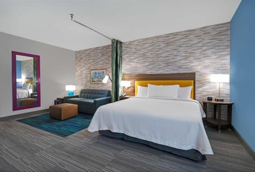 a hotel room with a bed and a couch at Home2 Suites By Hilton Springdale Cincinnati in Springdale