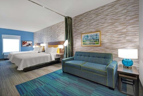 Habitación de hotel con cama y sofá en Home2 Suites By Hilton Springdale Cincinnati, en Springdale