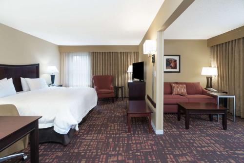 a hotel room with a bed and a couch at Hampton Inn Corydon in Corydon