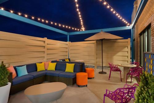 a patio with a blue couch and a table and chairs at Tru By Hilton Cheyenne in Cheyenne