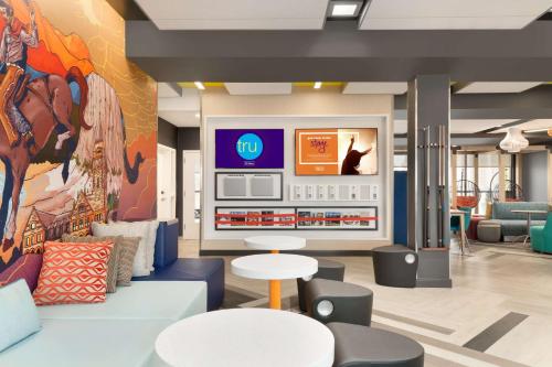 a lobby with couches and tables and a mural at Tru By Hilton Cheyenne in Cheyenne