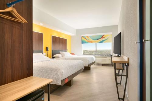a hotel room with two beds and a flat screen tv at Tru By Hilton Cheyenne in Cheyenne