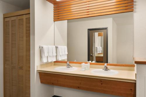 a bathroom with two sinks and a large mirror at Radisson Hotel Portland Airport in Portland