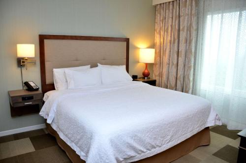 a bedroom with a large white bed with two lamps at Hampton Inn & Suites - DeLand in DeLand