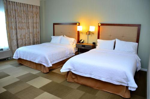 two beds in a hotel room with white sheets at Hampton Inn & Suites - DeLand in DeLand