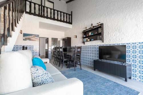 a living room with a couch and a television at T3 Praia do Baleal in Ferrel