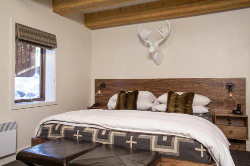 a bedroom with a large bed with a wooden headboard at Hotel Durant in Aspen