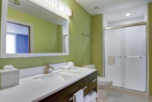 een badkamer met een wastafel, een toilet en een spiegel bij Home2 Suites by Hilton Irving/DFW Airport North in Irving