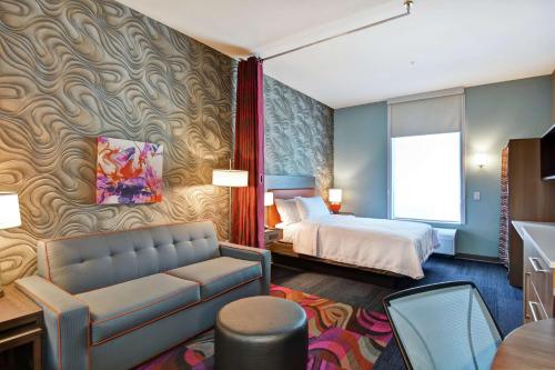 Habitación de hotel con cama y sofá en Home2 Suites By Hilton McKinney, en McKinney