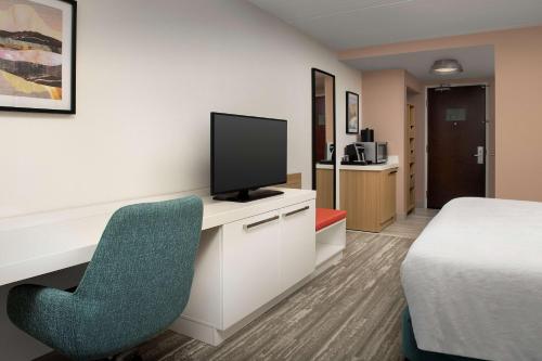a hotel room with a bed and a tv and a chair at Hilton Garden Inn Dallas/Duncanville in Duncanville