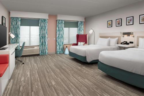 a hotel room with two beds and a tv at Hilton Garden Inn Dallas/Duncanville in Duncanville