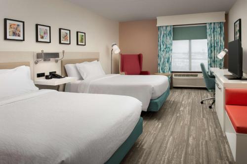 a hotel room with two beds and a tv at Hilton Garden Inn Dallas/Duncanville in Duncanville