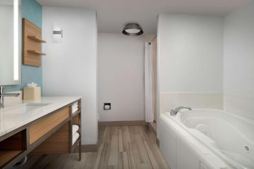 a white bathroom with a tub and a sink at Hilton Garden Inn Dallas/Duncanville in Duncanville