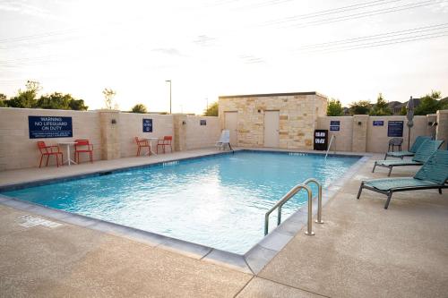 a large swimming pool with chairs and a table at Tru By Hilton Allen Dallas, Tx in Allen