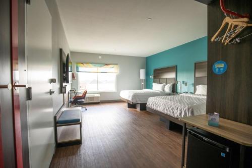 a hotel room with two beds and a desk and a room with a bed at Tru By Hilton Allen Dallas, Tx in Allen