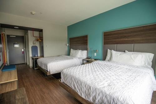 a hotel room with two beds and a blue wall at Tru By Hilton Allen Dallas, Tx in Allen