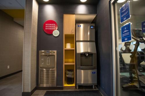 a large silver refrigerator in a room with a shelf at Tru By Hilton Allen Dallas, Tx in Allen