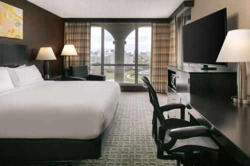 a hotel room with a bed and a desk with a television at DoubleTree by Hilton Dallas Market Center in Dallas