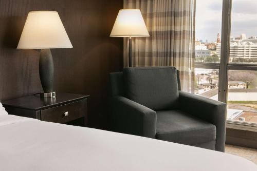 a hotel room with a chair and a window at DoubleTree by Hilton Dallas Market Center in Dallas