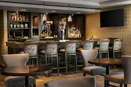 a bar in a restaurant with chairs and tables at DoubleTree by Hilton Dallas Market Center in Dallas