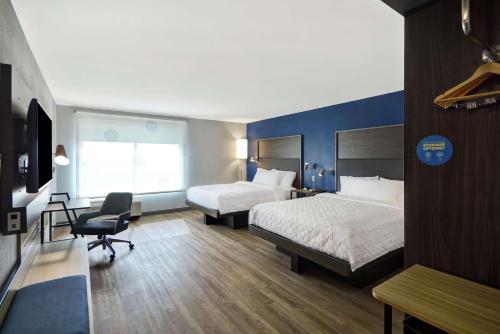 Habitación de hotel con 2 camas, escritorio y silla en Tru By Hilton Beavercreek Dayton en Fairborn