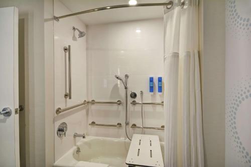 La salle de bains est pourvue d'une baignoire et d'une douche avec rideau de douche. dans l'établissement Tru By Hilton Beavercreek Dayton, à Fairborn