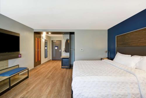 a hotel room with a large bed and a flat screen tv at Tru By Hilton Beavercreek Dayton in Fairborn