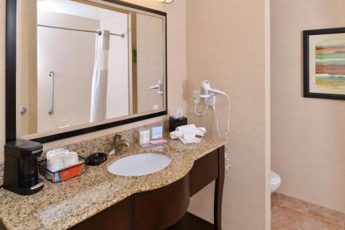 a bathroom with a sink and a mirror and a toilet at Hampton Inn by Hilton Dayton South in Miamisburg