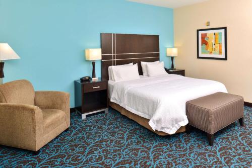 Habitación de hotel con cama y silla en Hampton Inn by Hilton Dayton South, en Miamisburg