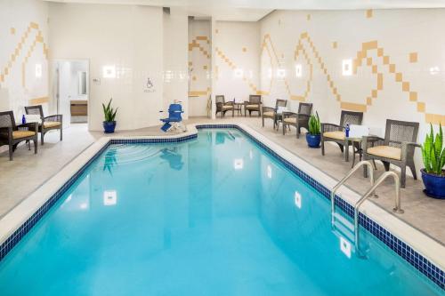 una piscina en una habitación de hotel con sillas y mesas en Hilton Garden Inn Washington DC Downtown, en Washington