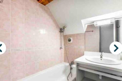 La salle de bains est pourvue d'un lavabo, de toilettes, d'une baignoire et d'un miroir. dans l'établissement Penthouse T2 Valmeinier 1900 skis aux pieds, à Valmeinier