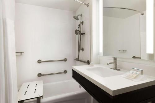 a white bathroom with a sink and a mirror at Hilton Garden Inn Washington DC Downtown in Washington