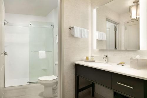 a bathroom with a sink and a toilet and a mirror at Homewood Suites By Hilton Arlington Rosslyn Key Bridge in Arlington