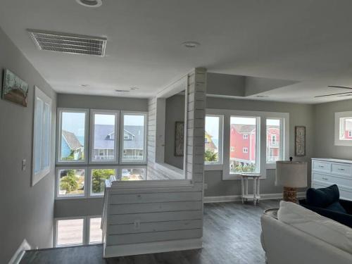 a living room with large windows and a couch at Holden Beach House Second Row with surround views! in Holden Beach