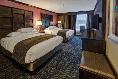 a hotel room with two beds and a flat screen tv at DoubleTree by Hilton Decatur Riverfront in Decatur